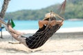 Lifestyle freelance man relax and sleeping on the hammock after using laptop working and relax on the beach. Royalty Free Stock Photo